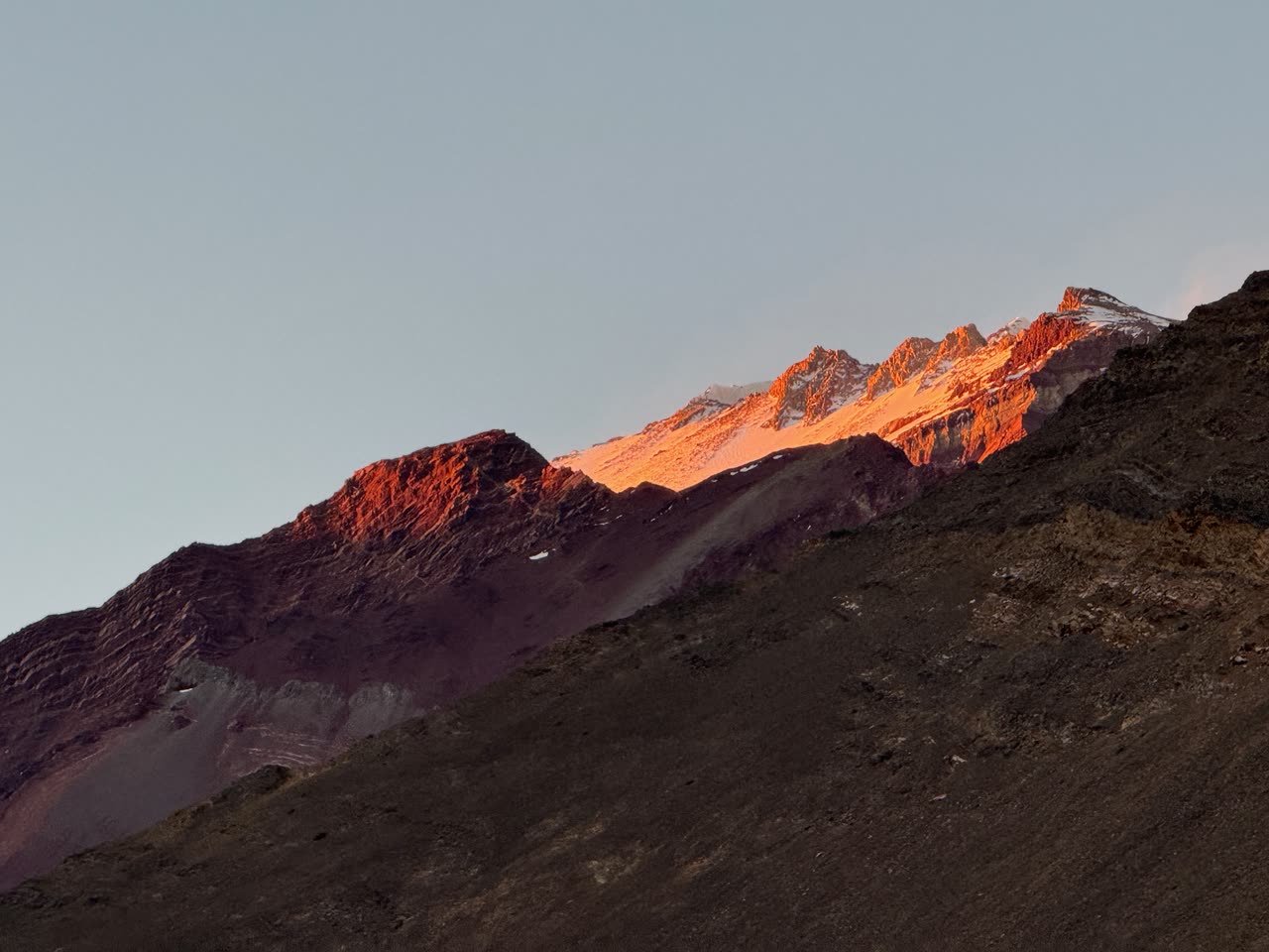 Mountain peak glowing orange at sunset