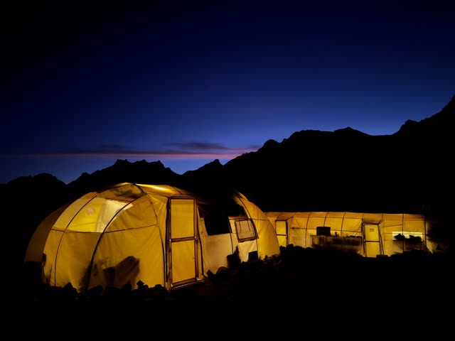 Yellow tents glowing from inside at night