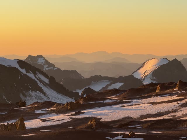 Distant snow-capped peaks catching last sun rays