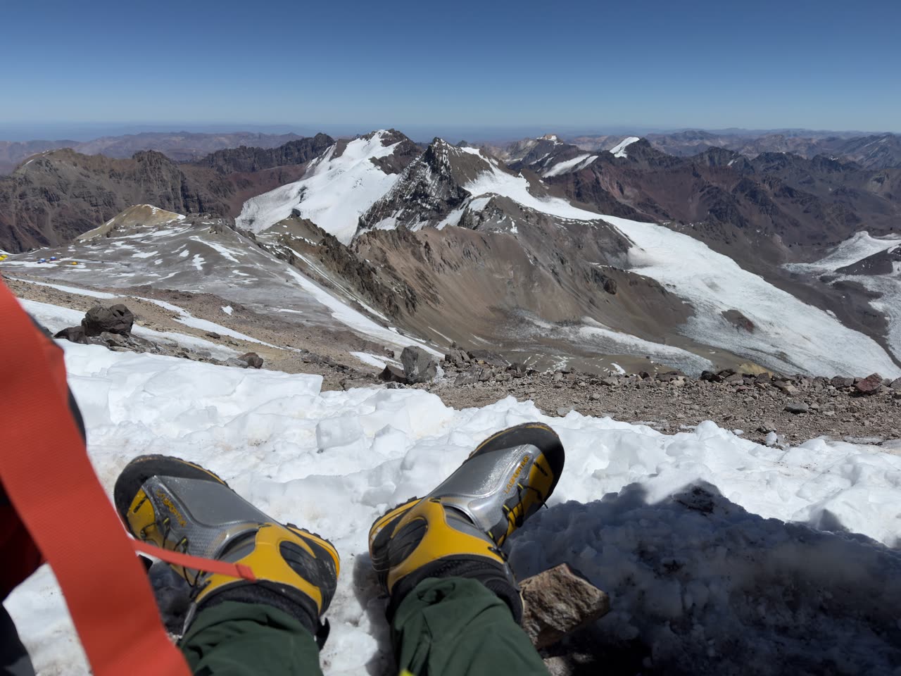 First-person view of boots on a rock, overlooking the summit of Aconcagua
