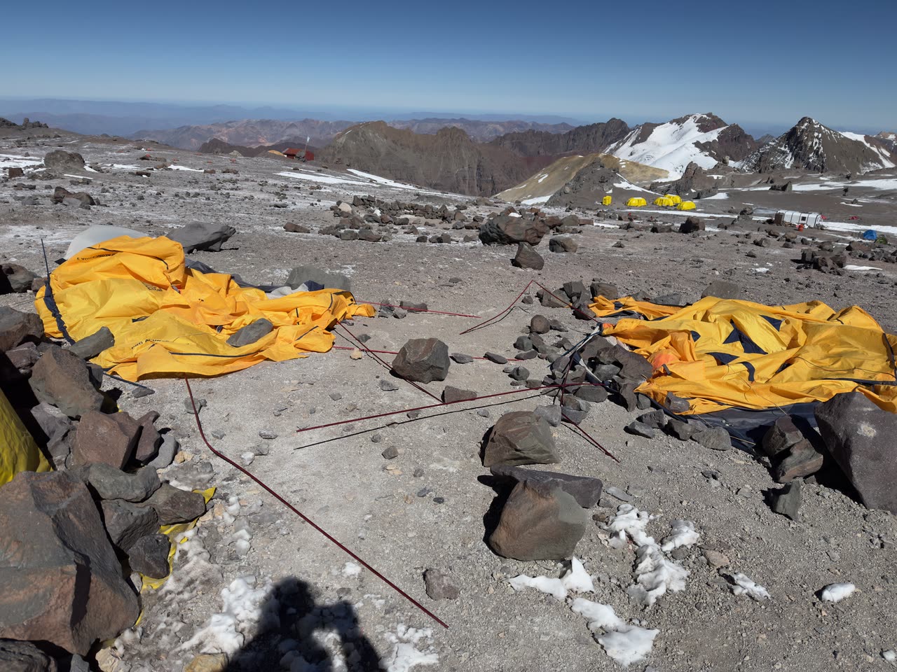 Windy campsite with tents being packed or flattened
