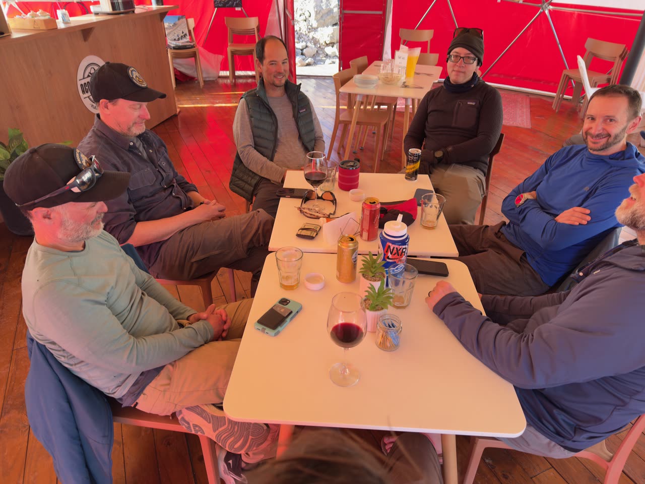 Group of climbers sharing a meal around a table in common tent