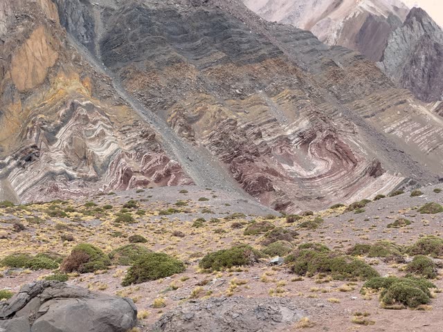 Multi-colored layered mountain slopes with trail