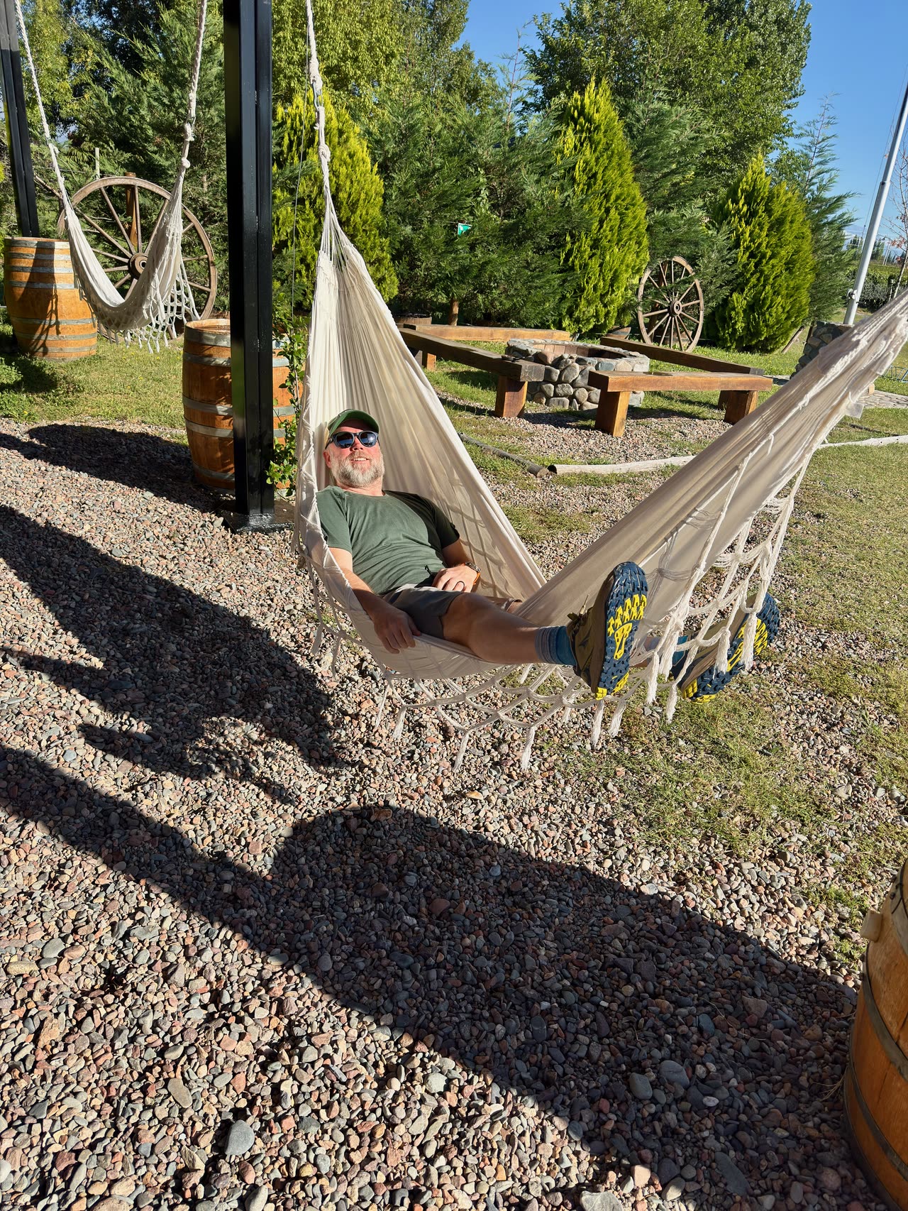 Person relaxing in hammock in vineyard garden