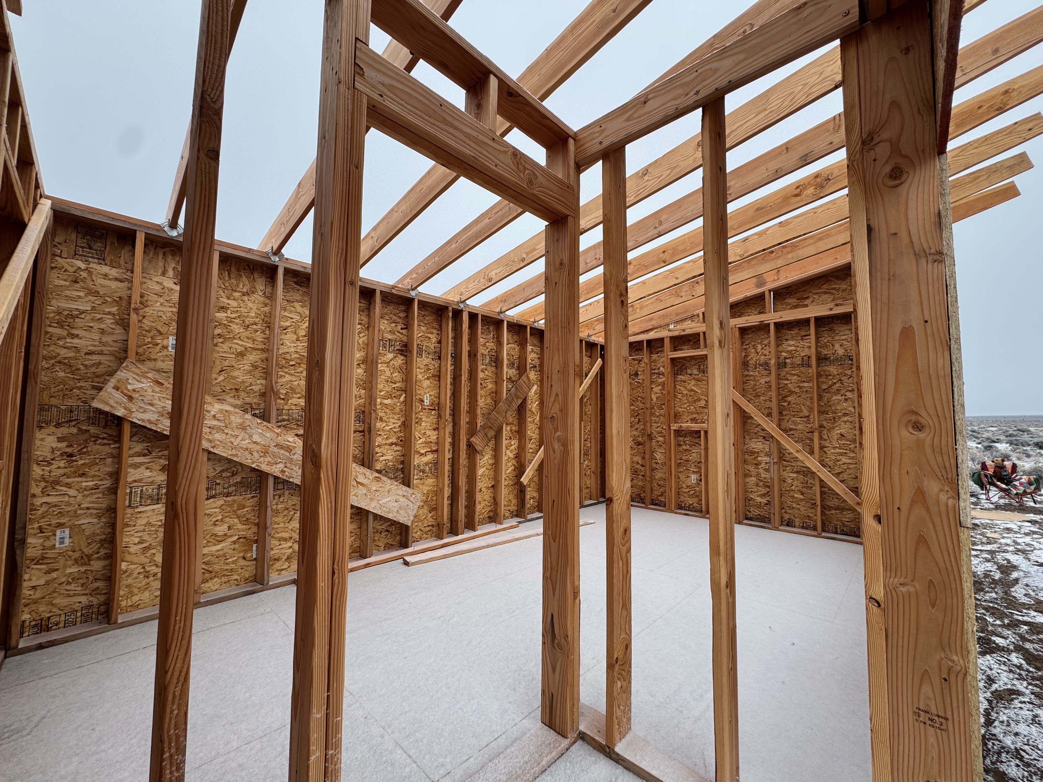 Inside the framed walls of a house, roof not yet on